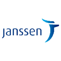 A professional team meeting at Janssen, discussing strategies with charts and laptops on the table.