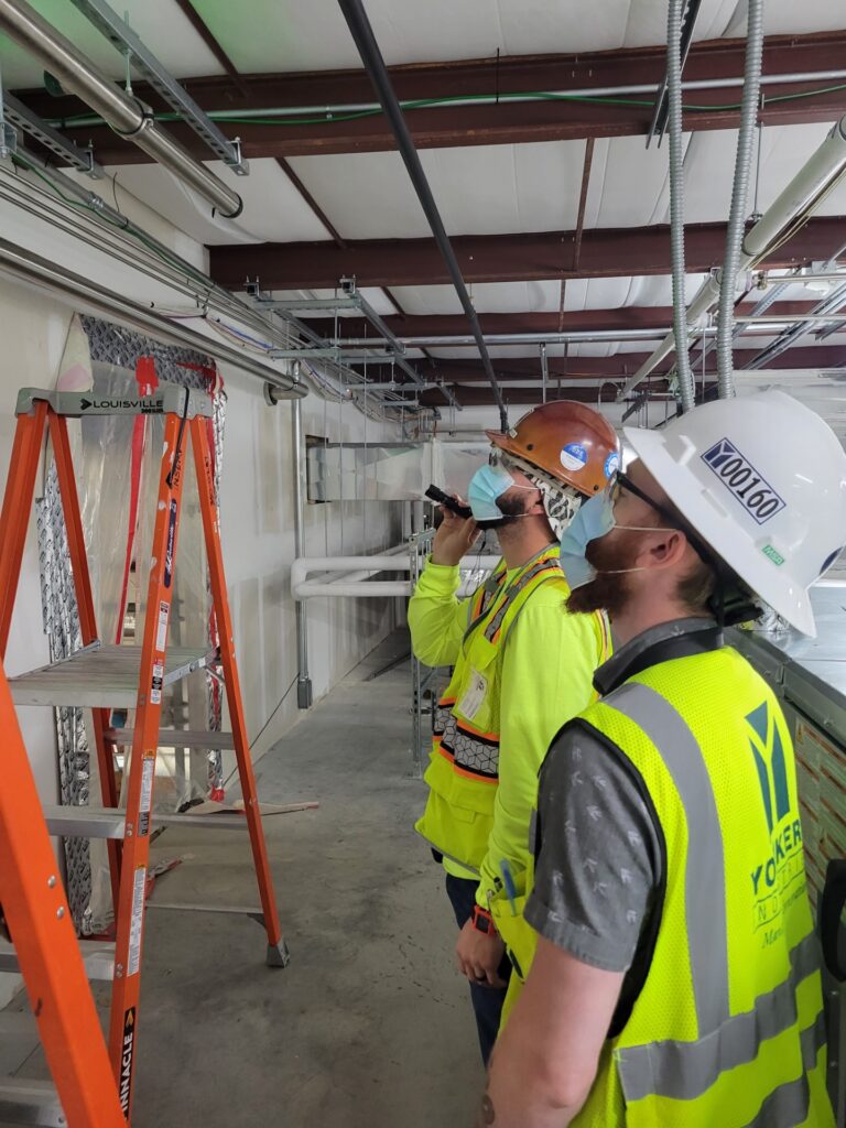 Construction site showcasing workers and machinery, highlighting yonkers industries construction management in action.