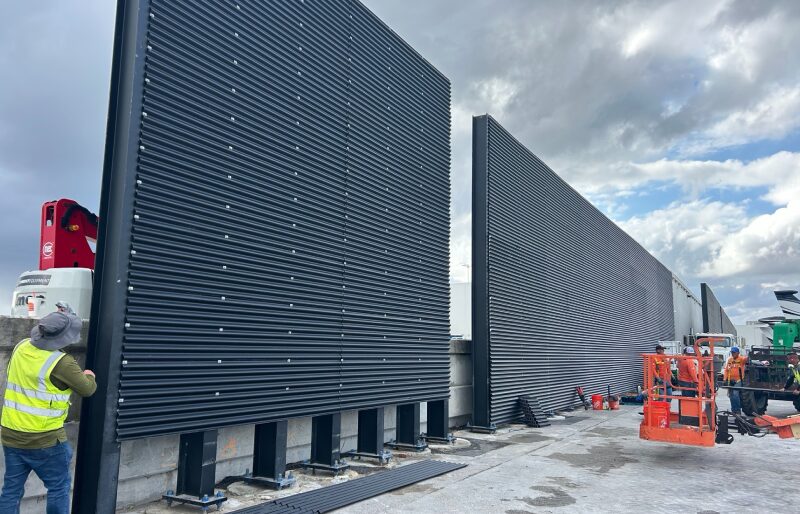 A modern construction site showcasing workers in hard hats, machinery, and building materials for the new project.